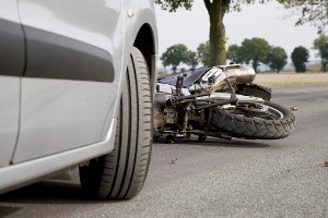 A motorcycle after hitting a car, where the owner will soon need a Motorcycle Accident Attorney in Peoria IL